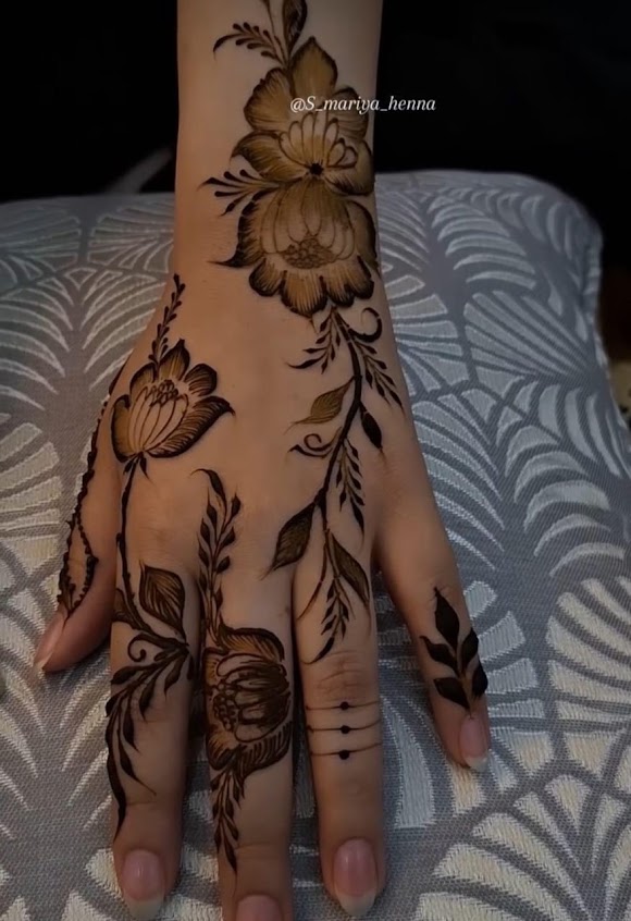 Rose and vine henna design on a hand