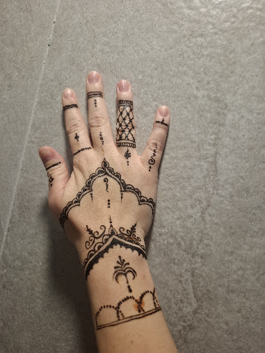 Fine-line geometric henna on the back of a hand