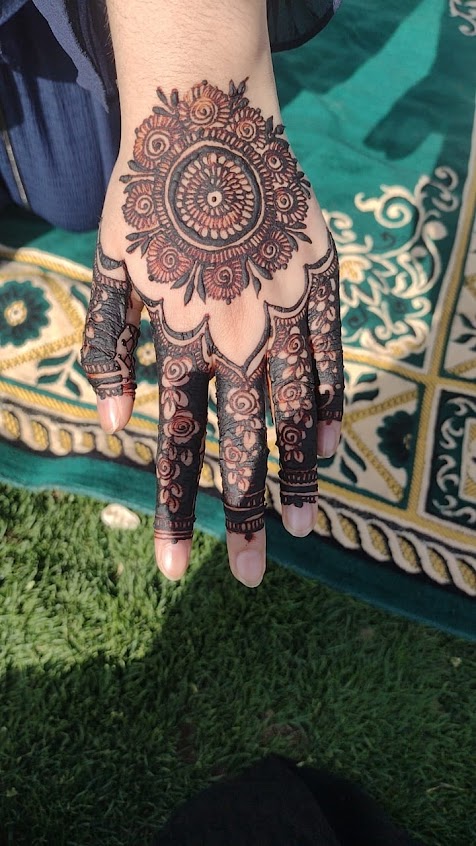 Round mandala henna on the back of the hand